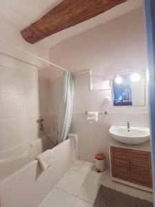 ein weißes Badezimmer mit Waschbecken und Badewanne in der Unterkunft Moulin de Monpoisson in Le Puy