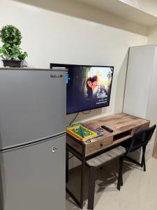 a kitchen with a refrigerator and a wooden table and a desk at Heart of Cebu Cozy Studio with Pool, Gym, Wifi and Netflix near Cebu City,Ayala and IT Park in Cebu City