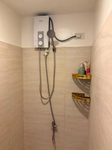 a shower in a bathroom with a blow dryer at Heart of Cebu Cozy Studio with Pool, Gym, Wifi and Netflix near Cebu City,Ayala and IT Park in Cebu City