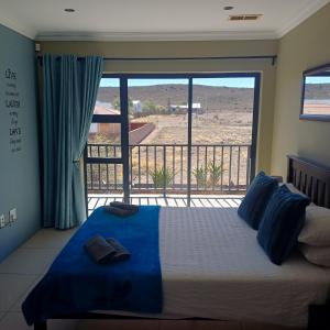 a bedroom with a bed with a view of the desert at Haus Holzapfel in Beaufort West