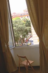 a chair and a window with a view of a street at Casa Fanti 57 in Rome