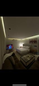 a bedroom with two beds and a couch and a tv at Studio in Al-Aqiq شقه رقم 15 و in Riyadh