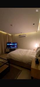 a bedroom with a bed and a flat screen tv at Studio in Al-Aqiq شقه رقم 15 و in Riyadh