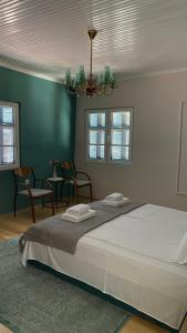 ein Schlafzimmer mit einem großen Bett und einem Kronleuchter in der Unterkunft Mihail Residence - Soul of Kavala in Kavala