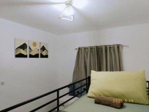 a bedroom with a bed and a ceiling fan at Sorelle- a cozy home in Manolo Fortich