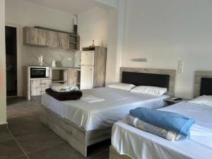 una camera con due letti e una cucina di Prionas Studios a Paralía Skotínis