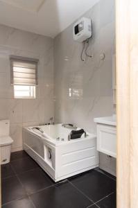 a white bathroom with a tub and a toilet at Serene 3BR self-compound in Lekki with Starlink WiFi in Lekki +9 photos