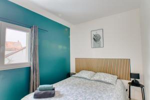 a bedroom with a bed and a blue wall at Appartement Spacieux 80 m2 in Bobigny