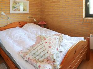 a bedroom with a white bed with a brick wall at Cozy Cottage near Mariager - By Traum Ferienwohnungen in Odde +4 photos