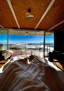 a bed in a room with a large window at Cabana panorâmica in Cunha