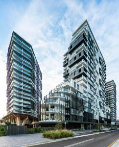 Dos altos edificios de cristal al lado de una calle en Luxe Park - 2B2B - 2min to Metroline 20min to CBD, en Sídney