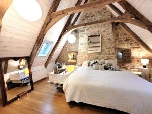 a bedroom with a large bed and a stone wall at La grange 