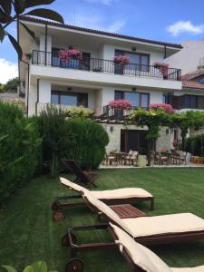 a house with chairs and tables in the yard at Guest House Balchik Hills in Balchik