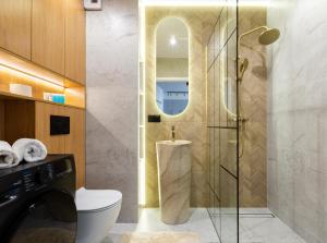 グダニスクにあるKazimierza Wielkiego Soft Glam Apartment by BookingHostのトイレとガラスのシャワー付きのバスルーム +26枚の写真