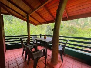 a table and chairs on a porch with a view at Ever After - Ella, Sri Lanka in Ella