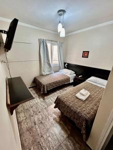 a hotel room with two beds and a television at Castelar in Mendoza