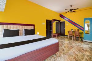 a bedroom with a bed and a table with chairs at Hotel O Cozee Homestay and Guest House in Sonārpur