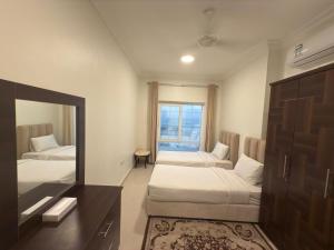 a hotel room with two beds and a mirror at Salalah golden villa in Salalah