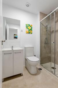 Un baño blanco con inodoro y ducha. en Apartamento New Metro 6pax, en Rivas-Vaciamadrid