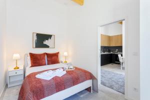 a white bedroom with a bed and a mirror at Bright Flat | Romantic Escape by HostWise in Porto