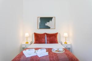 a bedroom with a bed with a plate of food on it at Bright Flat | Romantic Escape by HostWise in Porto
