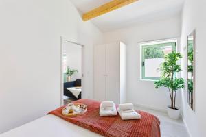 a white room with a bed with a red blanket at Bright Flat | Romantic Escape by HostWise in Porto +13 photos