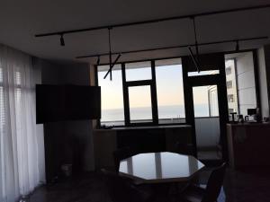 a living room with a table and some windows at Intourist Residence in Batumi