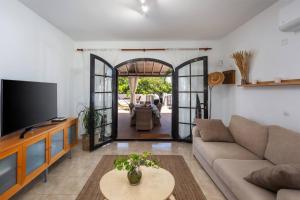 Una sala de estar con un sofá y un televisor. en Villa Garoé, en Puerto de las Nieves