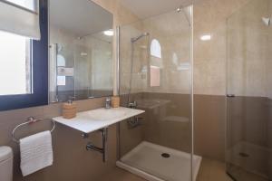 Un baño con lavabo y ducha de cristal. en Villa Garoé, en Puerto de las Nieves 42 fotos más
