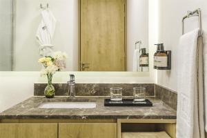 a bathroom with a sink and a mirror at NH Guadalajara Studios in Guadalajara +50 photos