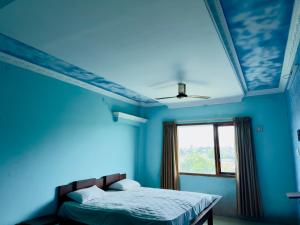 a blue bedroom with a bed and a window at Hotel City Towers, Nagore in kāraikāl
