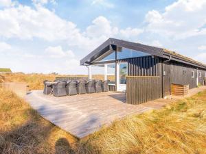 a wooden deck with chairs on top of a building at Charming Eco Cottage with Pool - By Traum Ferienwohnungen in Grønhøj