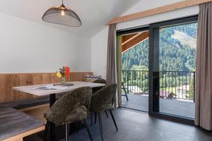 a dining room with a table and chairs and a balcony at Mountain Chalet Tribulaun Pflersch in Colle Isarco