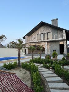 a large stone house with palm trees in front of it at VM Villa in Baku