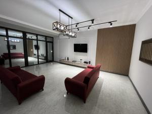 a living room with two couches and a flat screen tv at VM Villa in Baku