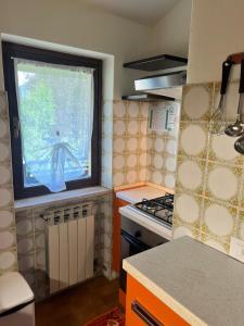 a small kitchen with a window and a stove at Wood & Fire Chalet in Borno +15 photos