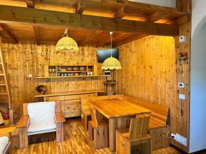 a dining room with a wooden table and chairs at Wood & Fire Chalet in Borno