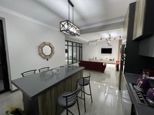 a kitchen and living room with a counter and chairs at VM Villa in Baku