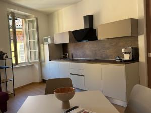 a kitchen with white cabinets and a table in a room at Largo A Zoppi in Cannobio