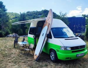 een wit-groene bus met een surfplank op de deur bij GoCamping Montenegro in Cetinje +8 foto's