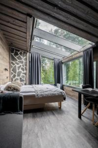 a bedroom with a bed and a large window at Koskisviitti 3 - Private Lakeside Suite with Terrace in Laukaa