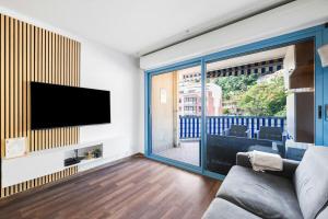 ein Wohnzimmer mit einem Flachbildfernseher an der Wand in der Unterkunft Le Virgil - Piscine - Parking Privé - Calme Wifi in Menton