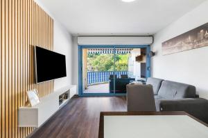 a living room with a flat screen tv and a couch at Le Virgil - Piscine - Parking Privé - Calme Wifi in Menton