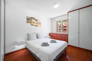 a bedroom with a bed with two towels on it at Le Virgil - Piscine - Parking Privé - Calme Wifi in Menton +20 photos
