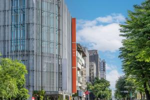 a tall building on a city street with trees at Retro Taichung in Taichung