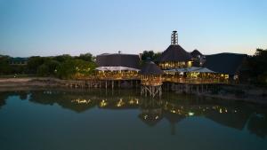 奥茨胡恩巴福士野生动物观光酒店的一间晚上在水面上点亮的餐厅