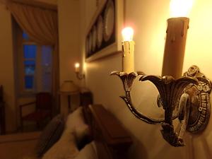a candle holder with two candles on a wall at Locadiera Pansion in Ermoupoli