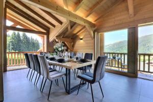une salle à manger avec une table, des chaises et des fenêtres dans l'établissement Résidence Goya - Chalet Goya - 10 Personnes - Les Gets MAE-0113, à Cohennoz
