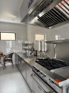 a stainless steel kitchen with a stove and a table at Hotel Black Sea Kobuleti in Kobuleti