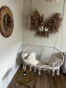 a swinging chair in a room with a mirror at Apartament Boho Monte 60 in Sopot